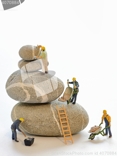 Image of Pebbles stack and figurines of construction workers
