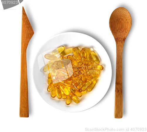 Image of Fish oil on plate with wooden knife and spoon