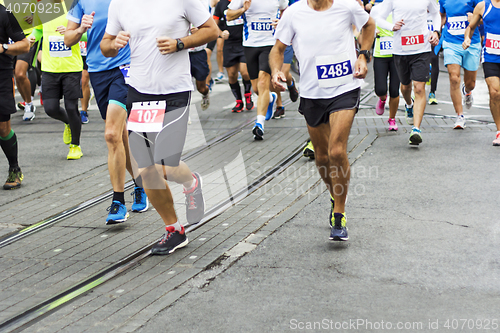 Image of Marathon runners race in city streets, blurred motion