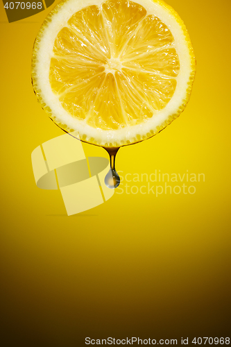 Image of Drop of fresh lemon juice falling down.