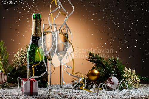 Image of Champagne, fir-tree branches with toys and gift box