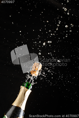 Image of Closeup of champagne explosion. Vertical image on black background