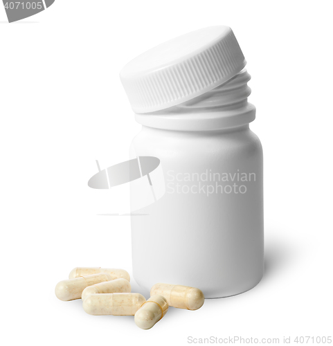 Image of Beige capsule near the plastic bottle