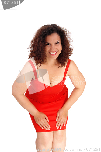 Image of Beautiful woman in red dress bending.