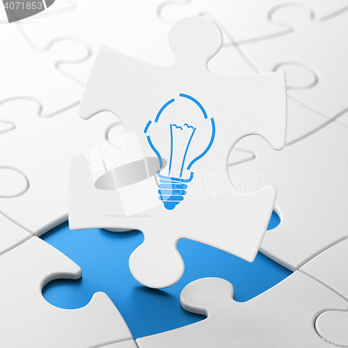 Image of Business concept: Light Bulb on puzzle background