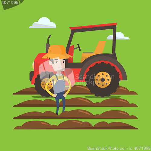 Image of Farmer standing with tractor on background.