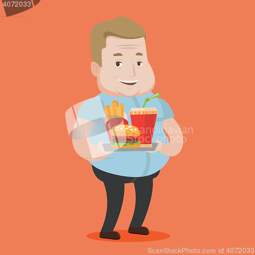 Image of Man holding tray full of fast food.