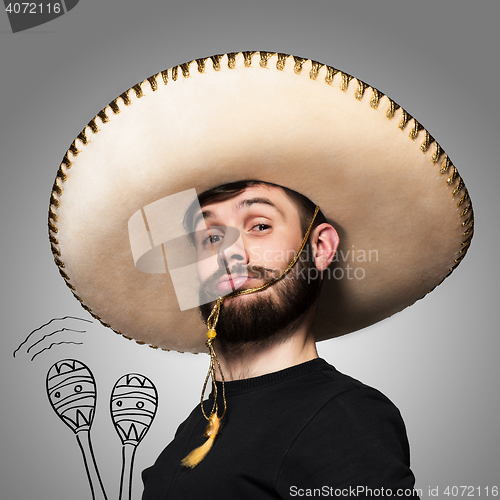 Image of portrait of funny man in Mexican sombrero on gray background