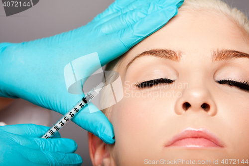 Image of Cosmetic plastic surgeon injecting aesthetics face