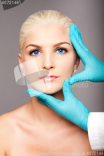 Image of Cosmetic plastic surgeon touching aesthetics face
