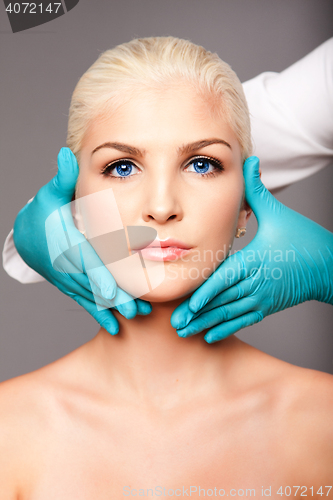 Image of Cosmetic plastic surgeon touching aesthetics face