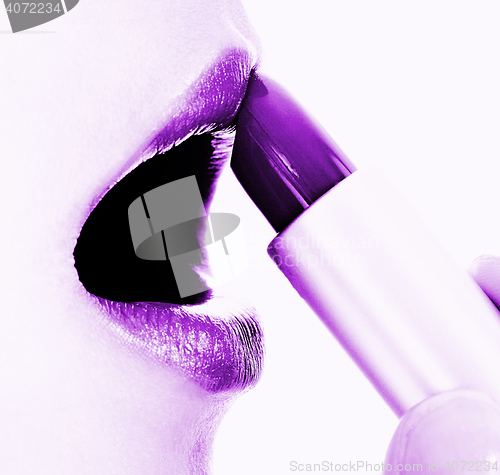 Image of Applying Mauve Or Purple Lipstick To Her Lips