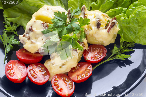 Image of Potatoes stuffed with bacon and small tomatoes close