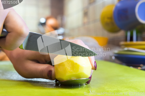 Image of Cook slices potato