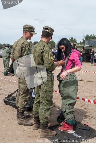 Image of Girl - visitor of show puts on sapper suit