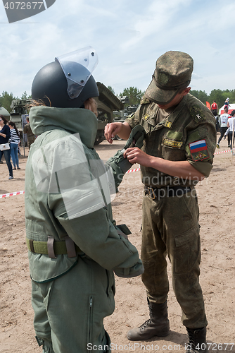 Image of Girl - visitor of show puts on sapper suit