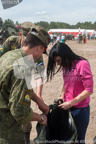 Image of Girl - visitor of show puts on sapper suit