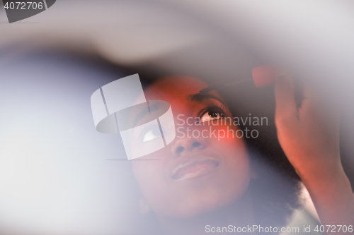 Image of a young African-American woman makeup in the car