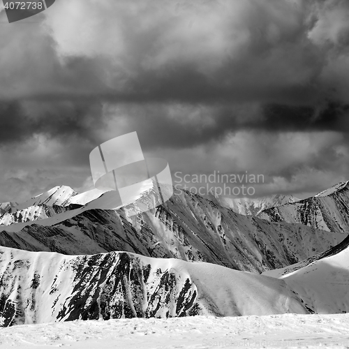 Image of Black and white winter snow mountains in dark storm clouds