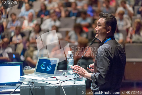 Image of Public speaker giving talk at Business Event.