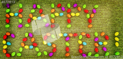 Image of Easter eggs as a \"Happy Easter\" greeting on a green grass. 3D il