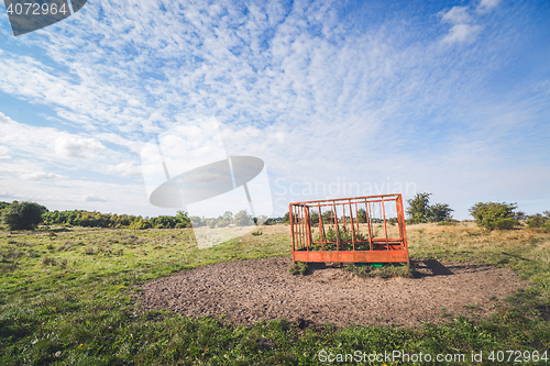 Image of Rural field with a red cage