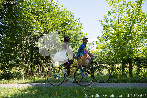 Image of Young multiethnic couple having a bike ride in nature