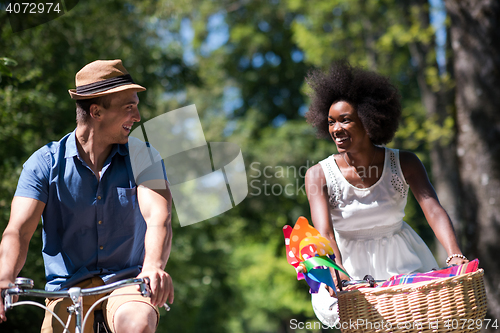 Image of Young multiethnic couple having a bike ride in nature