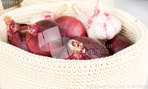 Image of red onions in a wicker basket close-up