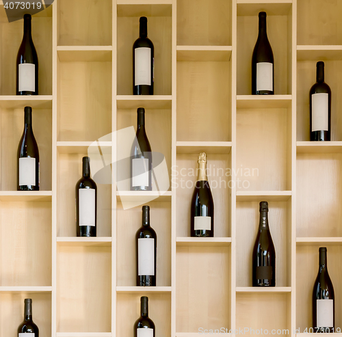 Image of variety bottles of wine and champagne in a wooden display case in the store