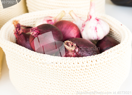 Image of red onions in a wicker basket close-up