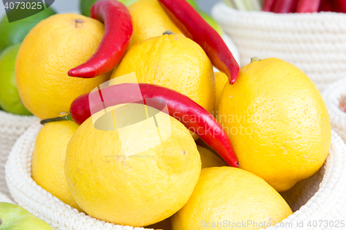 Image of lemons and chili peppers in a wicker basket close-up