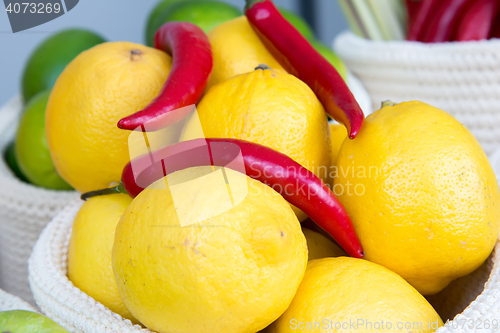 Image of lemons and chili peppers in a wicker basket close-up