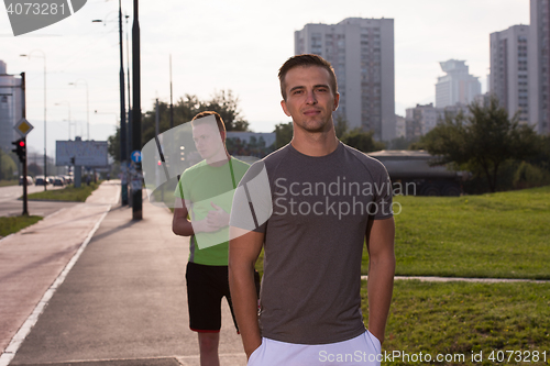 Image of Two young men jogging through the city