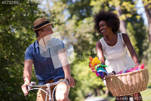 Image of Young multiethnic couple having a bike ride in nature