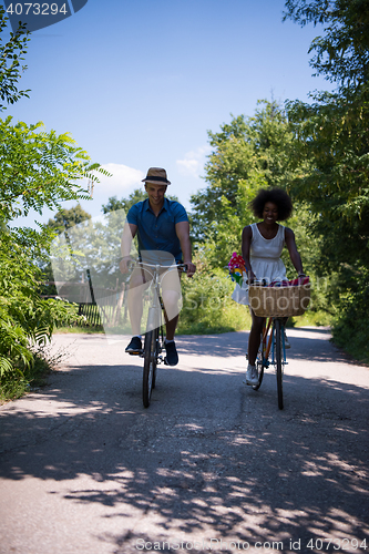 Image of Young multiethnic couple having a bike ride in nature