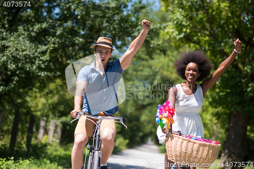 Image of Young multiethnic couple having a bike ride in nature