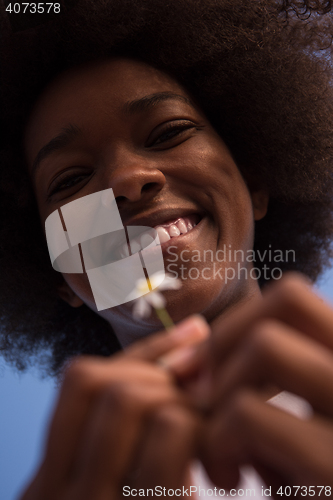 Image of portrait of African American girl with a flower in her hand