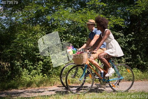 Image of Young multiethnic couple having a bike ride in nature