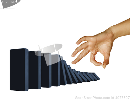Image of Hand toppling dominoes