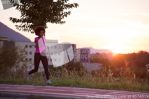 Image of a young African American woman jogging outdoors