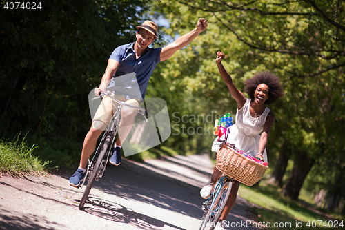 Image of Young multiethnic couple having a bike ride in nature