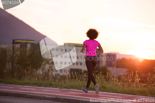 Image of a young African American woman jogging outdoors