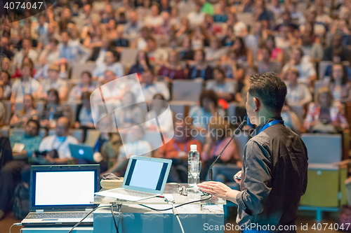 Image of Public speaker giving talk at Business Event.