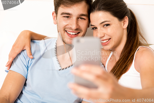 Image of Couple on bed making selfies