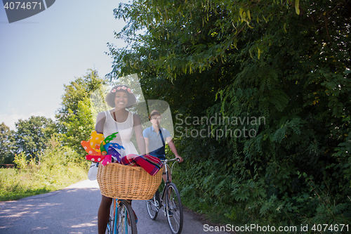 Image of Young multiethnic couple having a bike ride in nature