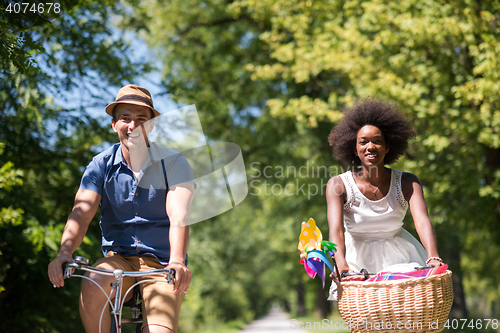 Image of Young multiethnic couple having a bike ride in nature