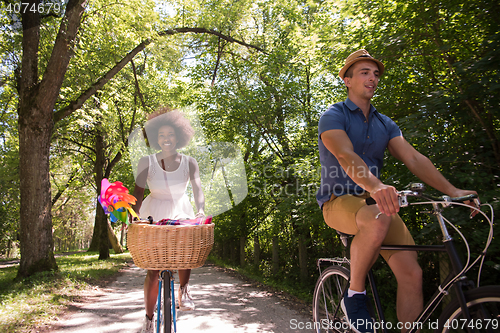 Image of Young multiethnic couple having a bike ride in nature