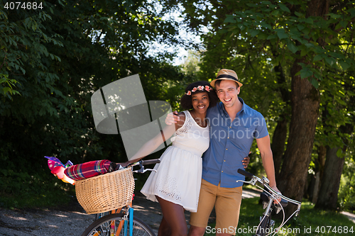 Image of Young multiethnic couple having a bike ride in nature