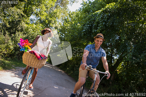 Image of Young multiethnic couple having a bike ride in nature